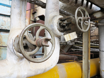 热水在火力发电厂的旧生锈工业管道阀门。