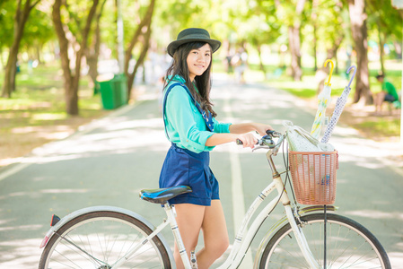 亚洲的年轻女子，与一辆自行车中夏公园