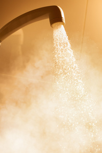 用流动的水和蒸汽洗热水澡照片