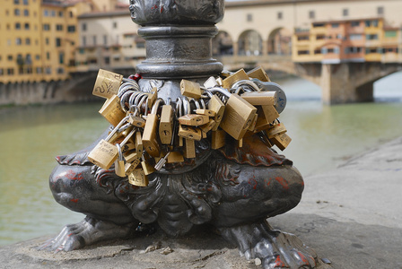 挂锁锁在阿尔诺河银行与 Ponte Vecchio 桥在意大利佛罗伦萨的背景
