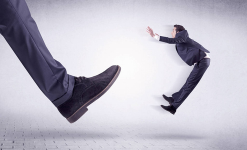 年轻的工人由大脚踢出摄影图