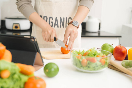 亚洲帅哥切菜在厨房里照片