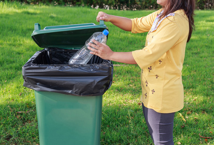 手把空塑料瓶扔进了垃圾桶照片