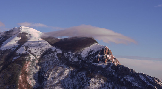 与雪的冬天日落，湛蓝的天空，云在山 Catria