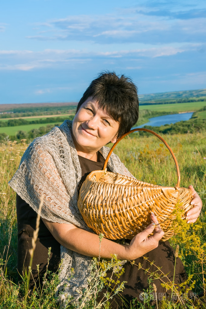 有魅力的女人,提着篮子在草原上