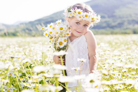 漂亮的小女孩与花束 chamomiles