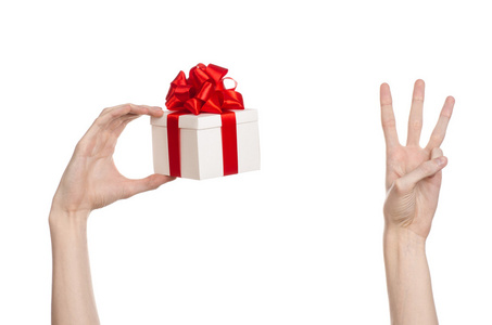包的节点庆祝活动和礼品的主题: 手拿着一个包裹在白色的盒子,带着弓