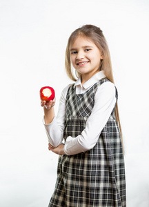 快乐的女孩，在学校制服拿着苹果的孤立的肖像