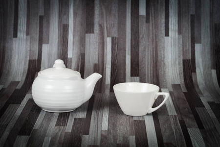 白茶壶和杯子在木头上