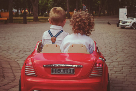 儿童男孩和女孩坐儿童车图片