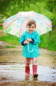 孩子是在雨中。一把雨伞。选择性的焦点