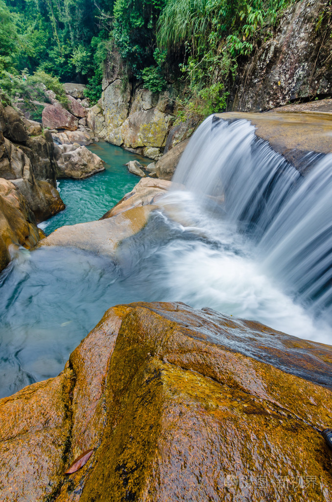 用流动的丛林瀑布水,巨大的岩石