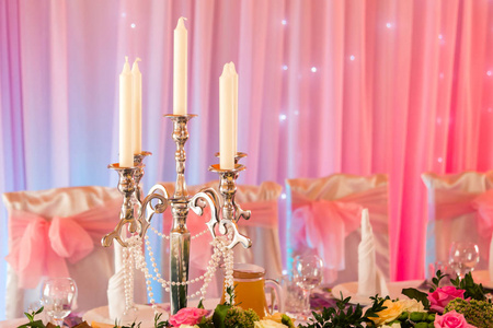 在宴会桌上温暖的粉红色背景烛台
