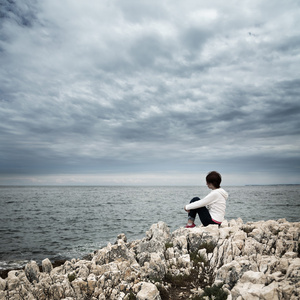 孤独的女子坐在波涛汹涌的海面