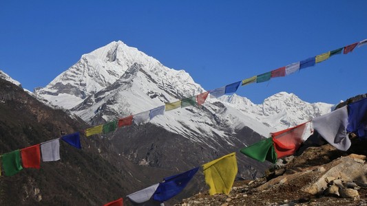 五彩经幡和白雪皑皑的高山