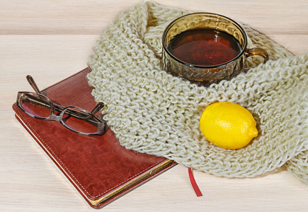 舒适和软冬天背景。杯茶，柠檬和温暖的针织毛衫或毯子上老式木板假期在家里。选择性的焦点