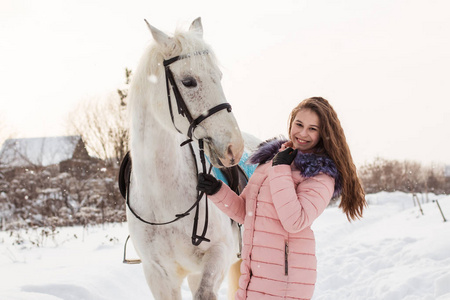 好女孩和白马户外冬季的降雪