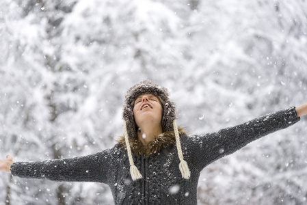 女人站在户外的落雪与她手臂的延伸