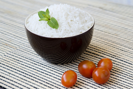 碗里的米饭配樱桃番茄照片