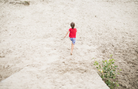 男孩在沙滩上赤脚跑