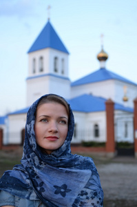 一个女孩斯拉夫俄罗斯出现在教会的背景上的一条围巾