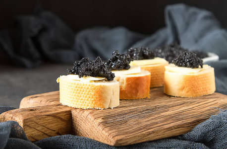 鱼子酱的黑色鲟鱼和白面包三明治.黑暗的 bac照片