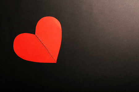 破碎的心缝了斯台普斯在黑色背景上照片