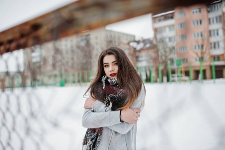 黑褐色休闲女孩在围巾在街道上的冬天