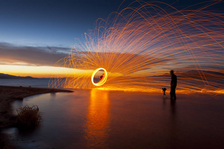 摄影师在湖拍摄图片旋转火花在日落时分。金字塔湖 内华达州
