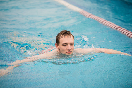 男子游泳在室内游泳池使用爬泳