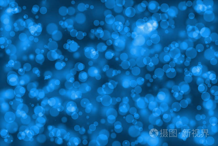 蓝颜色模糊散景为背景，圈圆形状抽象图形焦点效果出的魔法光
