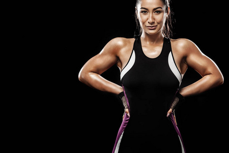 一个强壮的运动, 黑色背景的女人穿着运动服, 健身和运动动机