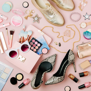 女式时尚饰品化妆用品和手袋的平躺在粉彩色彩背景下