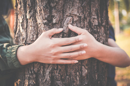 女性拥抱大树色的时髦色调选择性软聚焦概念性和人保护环境照片