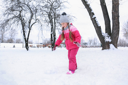 可爱的女孩在雪公园冬天假期