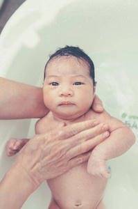 初生女婴与母亲帮忙洗澡