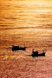 美丽的日落和本地渔船，在沙敦府，泰国安达曼海利普岛的海边