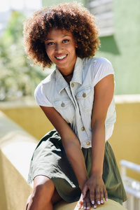 年轻的黑人妇女, 非洲的发型, 微笑的城市背景