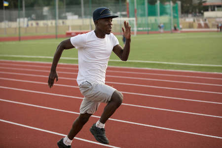 非洲男运动员在帽上体育场跑道快速运行距离短，他的训练速度
