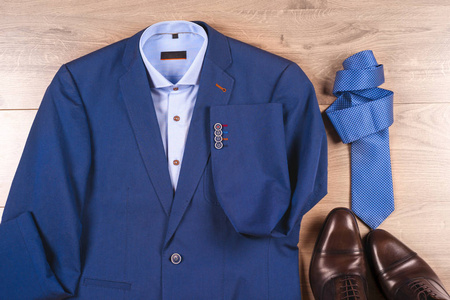 一套经典男装衣服蓝色西装 衬衫 棕色的鞋子，带上木背景的领带