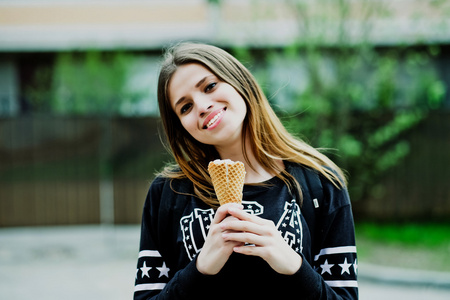 年轻女人吃冰激淋晴天户外