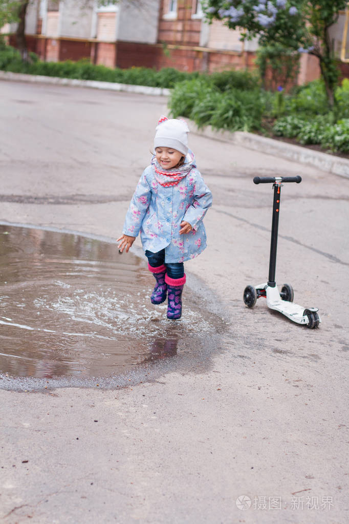 在水坑里跳的小女孩
