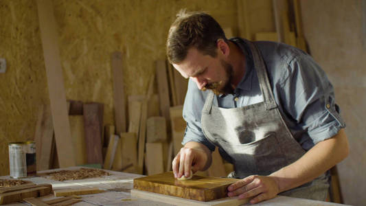 关闭的木匠木工磨漆在一块木板上的手
