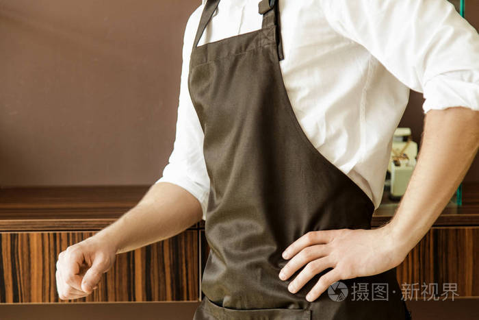 穿着围裙和衬衫的男人的手.特写