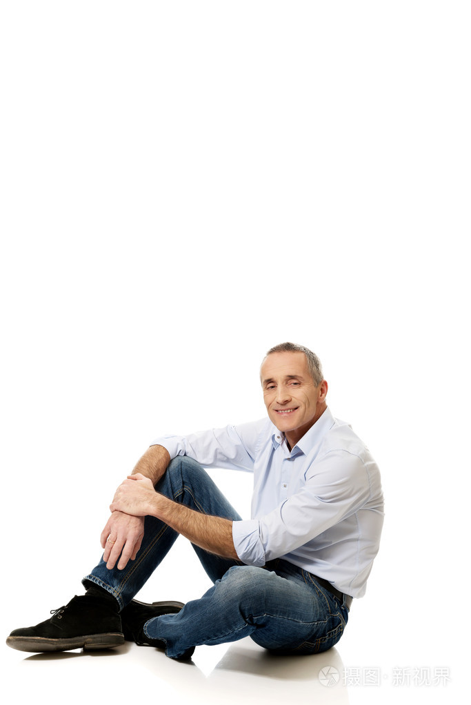 成熟的男人坐在地板上
