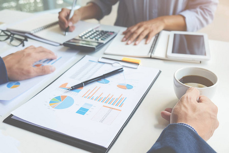 商界人士在讨论图表和图形显示出结果,他们成功的团队工作照片