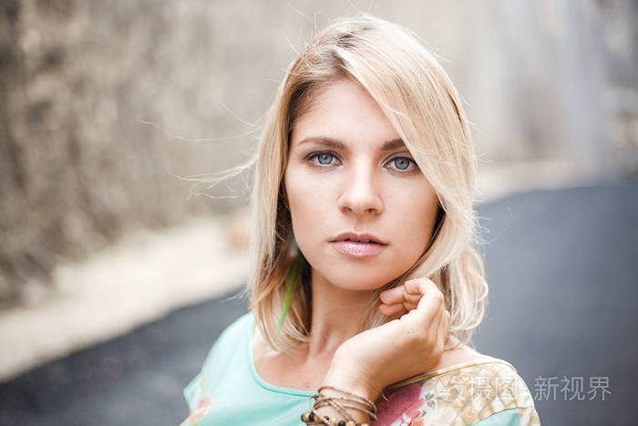 横向特写肖像的穿着与抽象打印灰色眼睛的金发女孩正站在山和寻找在