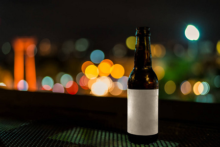 与夜啤酒玻璃瓶轻散景背景图片