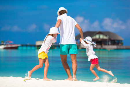 快乐爸爸和可爱的小女孩，在热带海滩玩乐