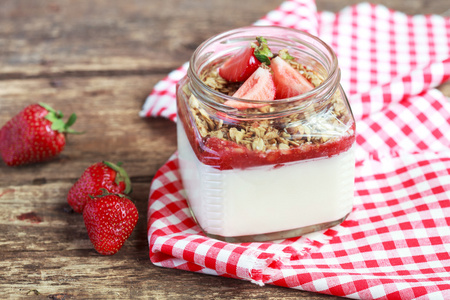 将自制酸奶放在一个装有草莓酱的罐子里照片